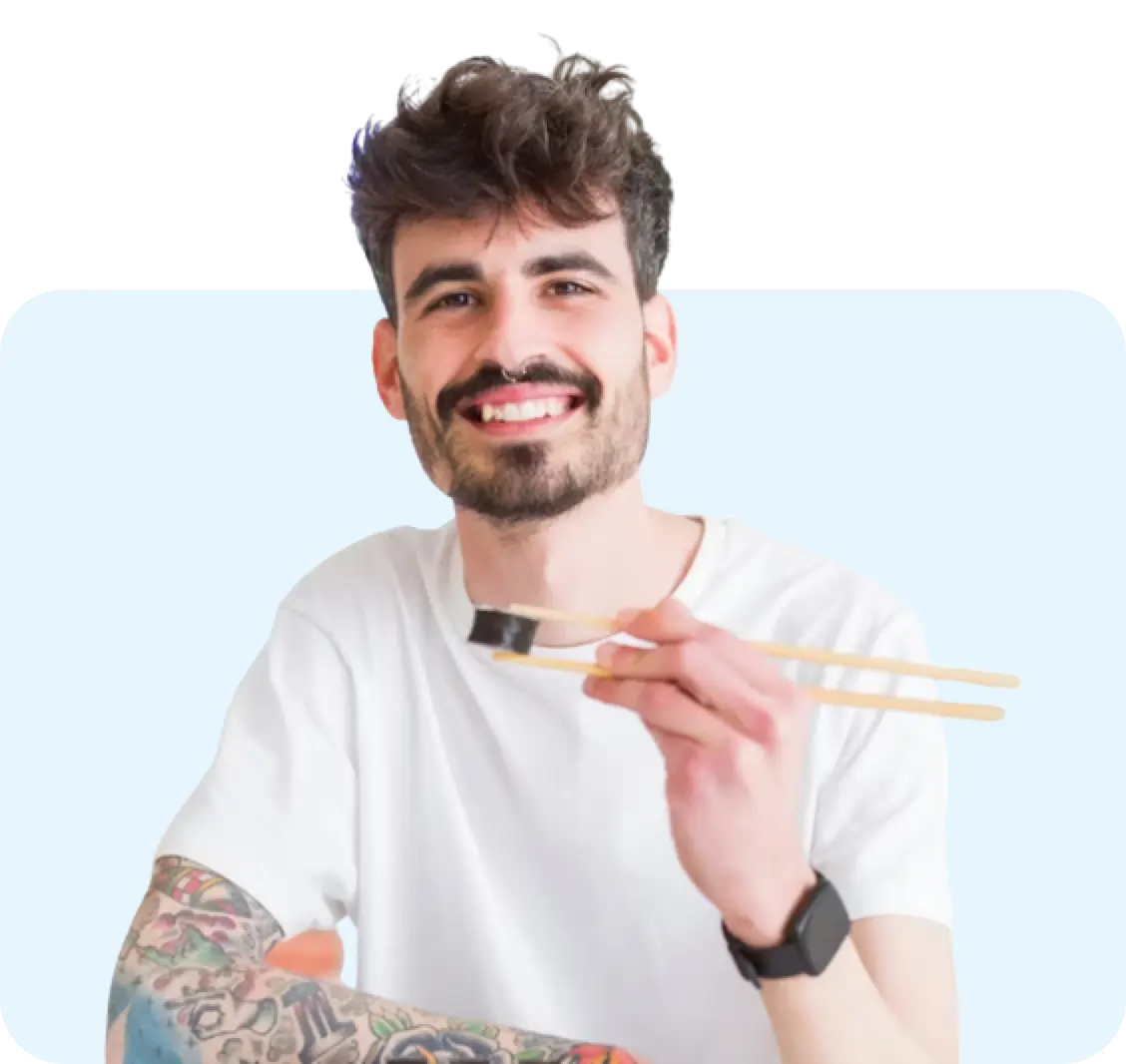 Man eating a sushi roll with chop sticks